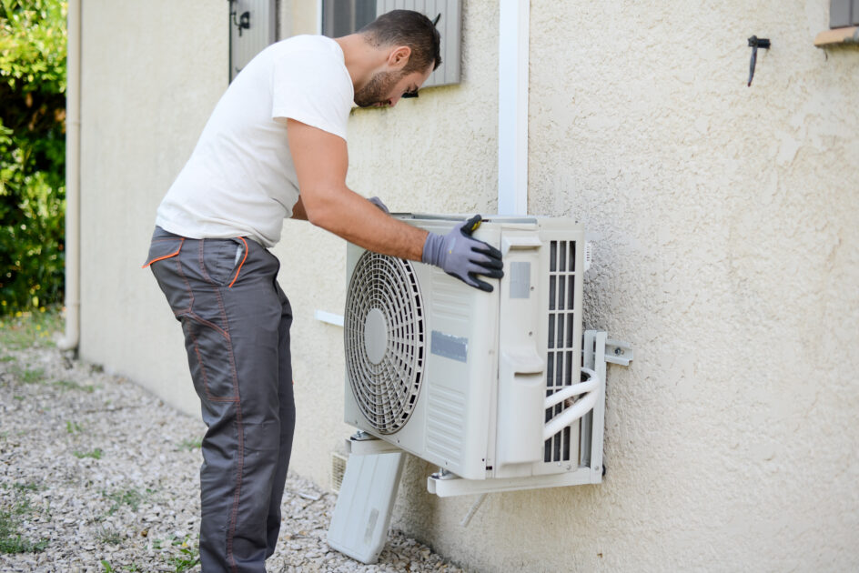 Image d'une personne installant un bloc clim extérieur