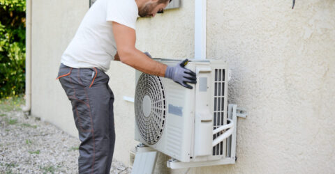 Image d'une personne installant un bloc clim extérieur