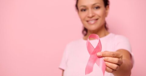 Image d'une femme qui tient un ruban rose au bout des doigts